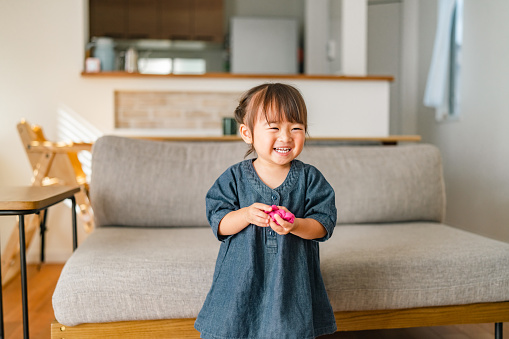 A portrait of a small girl in the living room at home.