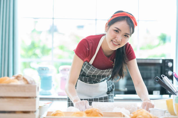 istock portrait woman with apron rolling out dough or flour on kitchen table 1352098375