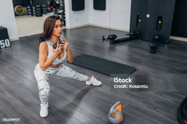Holding Weights In Her Hands A Young Woman Exercises In The Gym It Transfers Weight To One Leg And Thus Activates All The Muscles In The Body Stock Photo - Download Image Now