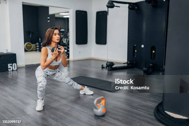A Young Female Athlete Does Leg Exercises In The Gym She Holds Weights In Hands And Thus Creates A Greater Effort With Which She Will Progress Faster Stock Photo - Download Image Now