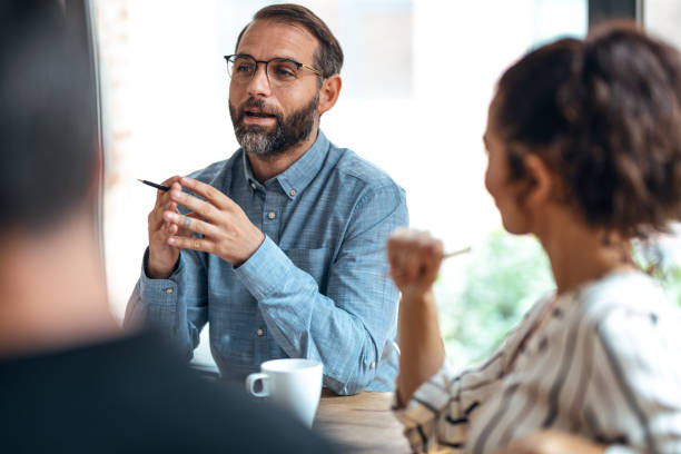 istock Casual multiage business people working with laptops while talking of they new project together in the office. 1352099827