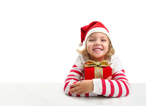 Child girl in santa hat with christmas present on white background. Happy kid with gift box. New year.
