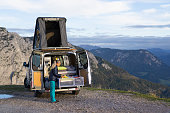 Rear View Camper Van and Woman in Mountains