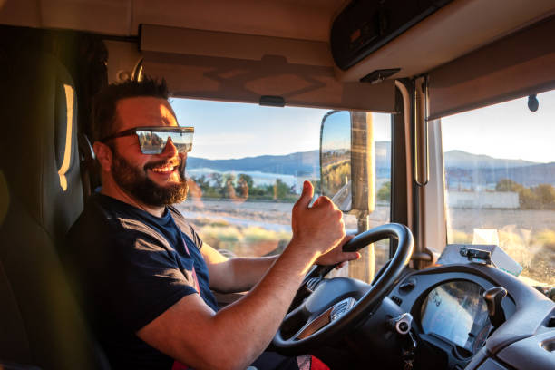 conductor de camión pesado feliz de poder conducir un camión, y haciendo el gesto de ok, con el pulgar hacia arriba. - truck driver truck driver driving fotografías e imágenes de stock