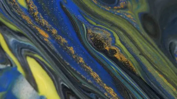 Abstract colorful background of spreading colors. Abstract dark paint background. Acrylic texture with marble pattern. Abstract-ART. Natural luxury. The style includes the vortices of marble or the ripples. Very beautiful blue, black, red, yellow, gray paint with the addition of gold powder.