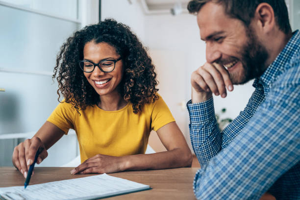Business people signing a contract. Shot of two business persons filling in paperwork in an office. Businessman and businesswoman signing a document in board room. sales executive stock pictures, royalty-free photos & images