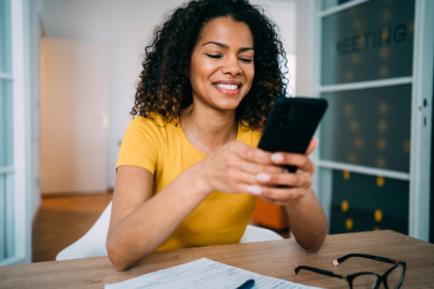 istock Woman using mobile phone in the office. 1352104208