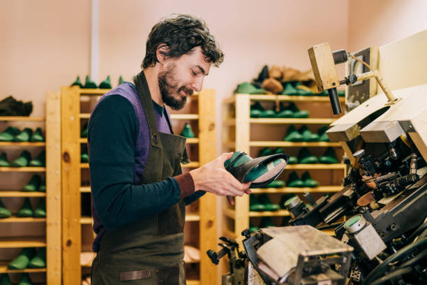 Young shoemaker in the workshop. Shot of confident craftsperson making a leather luxury shoes in his workshop. shoe mold stock pictures, royalty-free photos & images