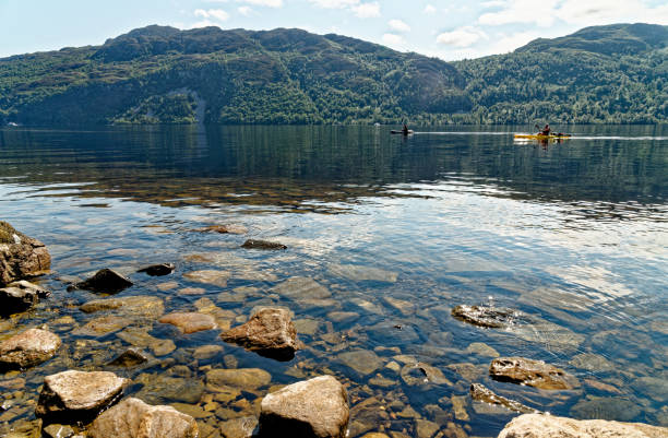 Kayaking on Loch Ness in the Scottish Highlands - Scotland Kayaking on the water of the Loch Ness in the Scottish Highlands. Loch Ness, Scotland - 20th of July 2021.The beauty of the Scottish Highlands across the width of Loch Ness. fort augustus stock pictures, royalty-free photos & images