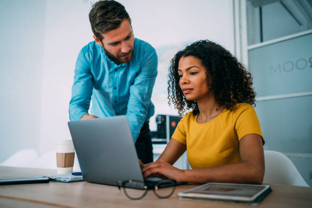 istock Confident business partners working on laptop in office. 1352105586