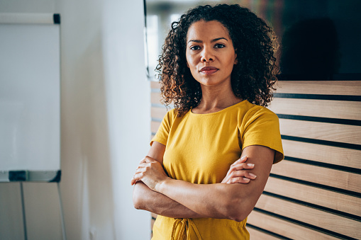 Shot of beautiful african-american businesswoman standing with crossed arms and looking at camera.