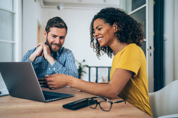 socios comerciales seguros de sí mismos que trabajan en una computadora portátil en la oficina. - human resources people young adult business fotografías e imágenes de stock