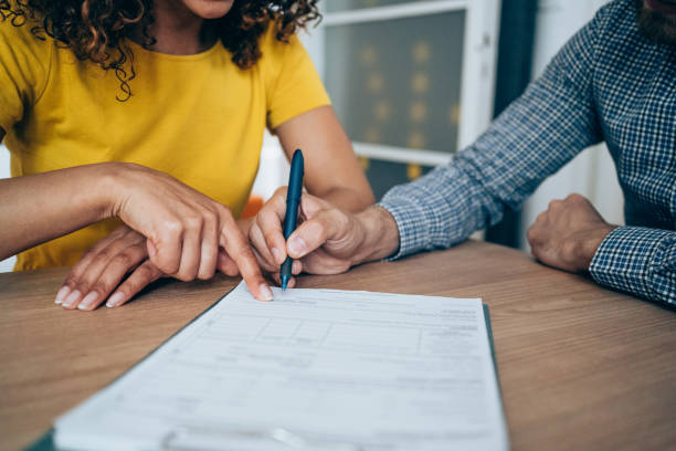 Business people signing a contract. Shot of two business persons filling in paperwork in an office. Businessman and businesswoman signing a document in board room. contract stock pictures, royalty-free photos & images