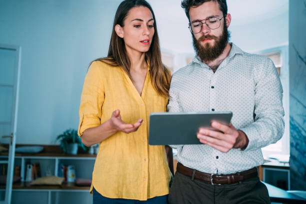 istock Confident business partners working on digital tablet in office. 1352105677