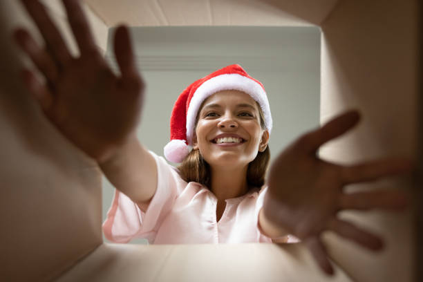 istock Excited Christmas gift receiver in Santa hat taking present wrap 1352105928