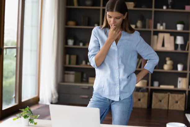 istock Thoughtful young employee working at laptop from home 1352106474