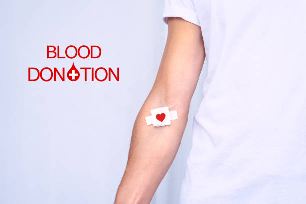 World blood donor day. Blood donation. Blood donor with bandage after giving blood World blood donor day. Blood donation. Blood donor with bandage after giving blood. High quality photo blood test stock pictures, royalty-free photos & images