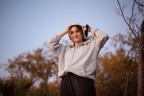 istock Young woman looking at camera while holding hoodie 1352107222