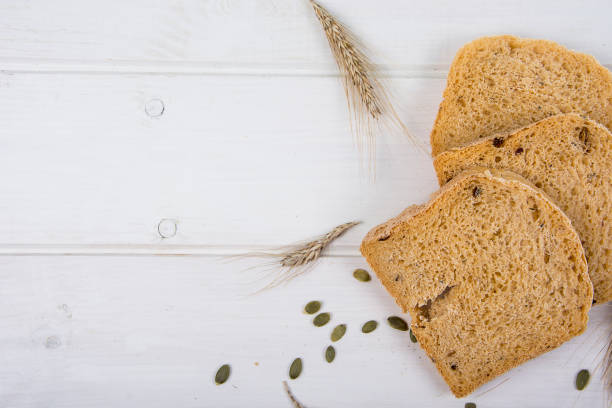 istock Wheat yeast rustic bread with pumpkin seeds on white wooden board background 1352107320