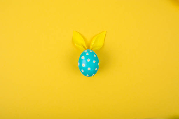 istock Egg with paper ears in the shape of an Easter bunny. Happy Easter Concept Card Postaer Background 1352107335