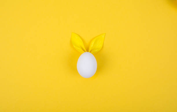 istock Egg with paper ears in the shape of an Easter bunny. Happy Easter Concept Card Postaer Background 1352107336