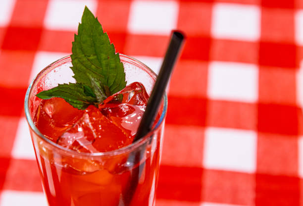 istock Red drink with ice cubes and green leaf 1352107730