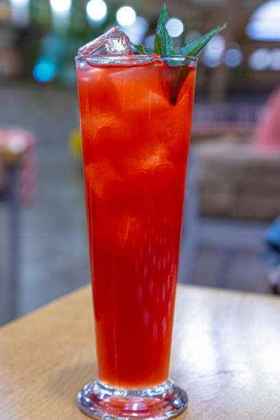 istock Red drink with ice cubes and green leaf 1352107731