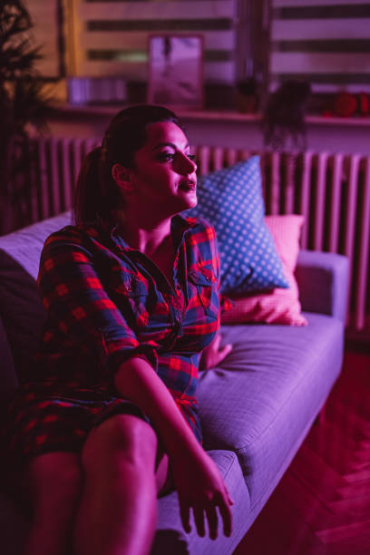 istock Beautiful young woman sitting on sofa 1352108468