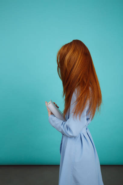 istock Side view of woman in bathrobe holding book 1352108483