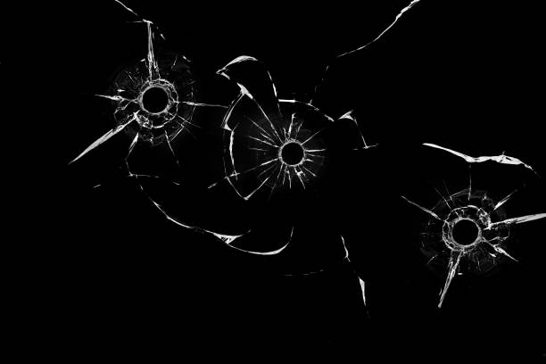 istock bullet holes in glass close up on black background 1352109099