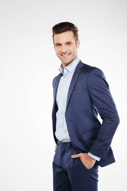 istock Vertical image of smiling business man with arms in pockets 1352110187