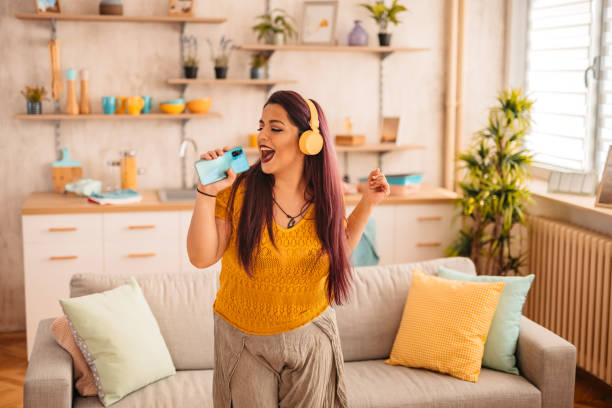 istock Woman singing and dancing at home 1352110305