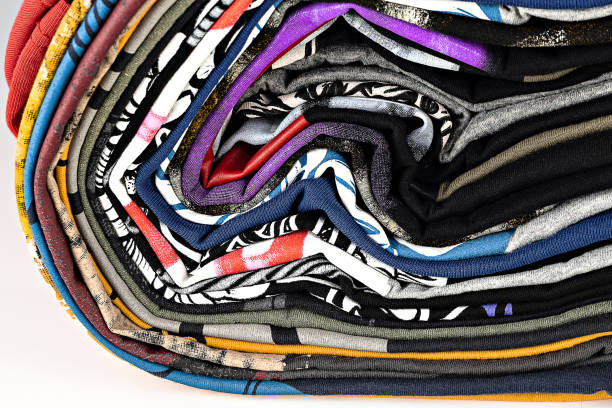 t-shirts with bright prints, printed by silkscreen. serigraphy production. printing images on tshirts in a design studio. selective focus photo