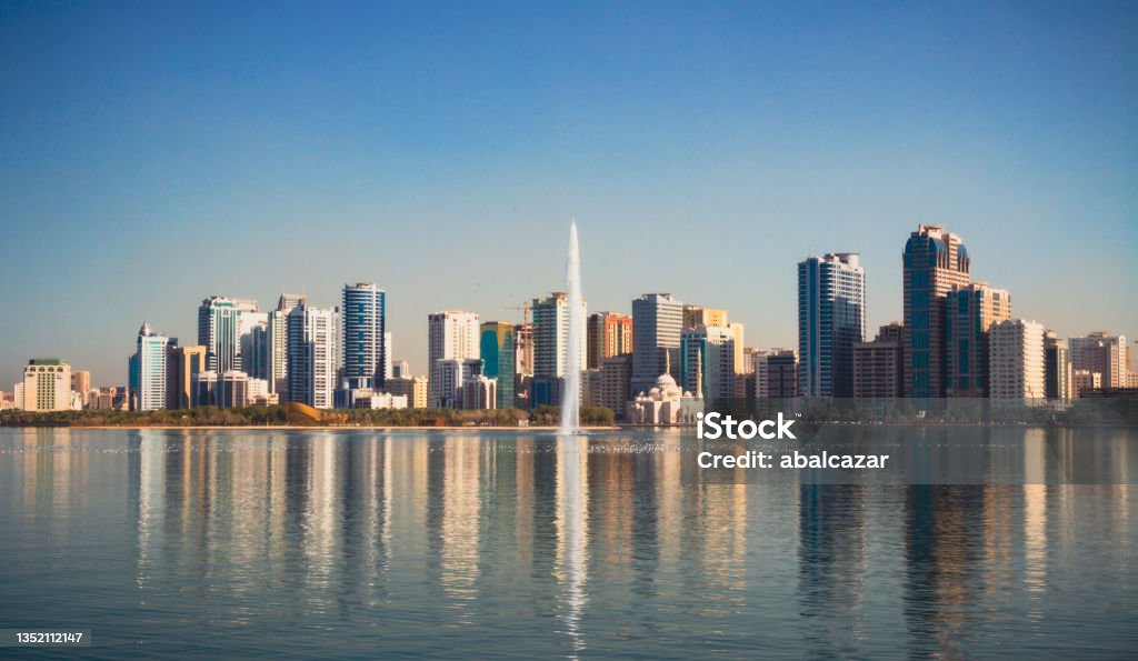 Noor mosque, Sharjah, UAE Noor Mosque and jet stream in Khalid Lake, with the city skyline in the background Sharjah City Stock Photo