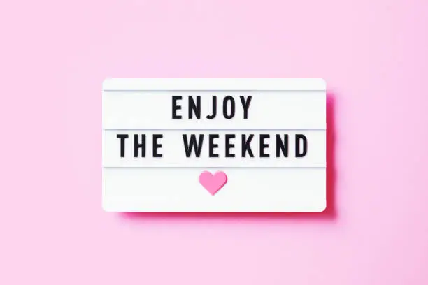 Photo of Enjoy The Weekend Written White Lightbox Sitting On Pink Background