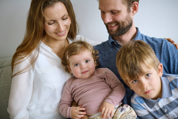 istock Family sitting on sofa at home 1352113081
