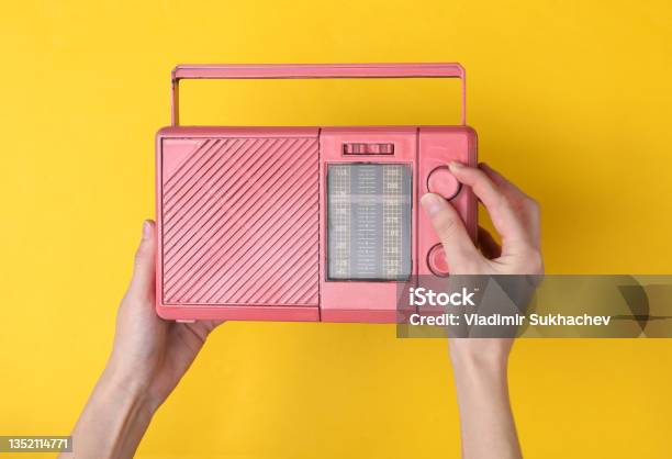 Female Hands Holding Pink Fm Radio Receiver On Yellow Background Music Minimal Concept Stock Photo - Download Image Now