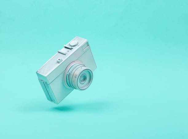 istock Levitating white camera on blue background. 3D photo. Minimalistic still life. Creative layout. Concept art 1352114804