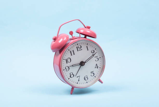 istock Levitating pink alarm clock on colored background. 3D photo. Minimalistic still life. Creative layout. Concept art 1352114817