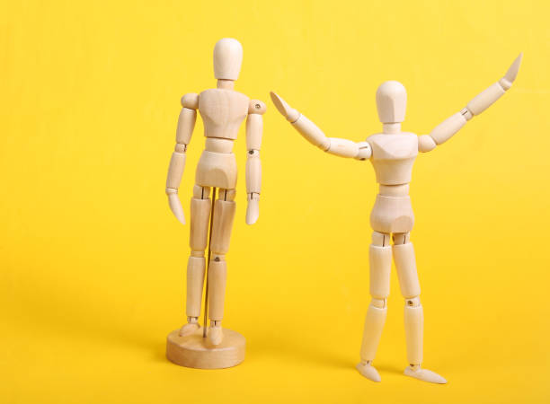 istock Freedom concept. Two puppets on a yellow background 1352114836