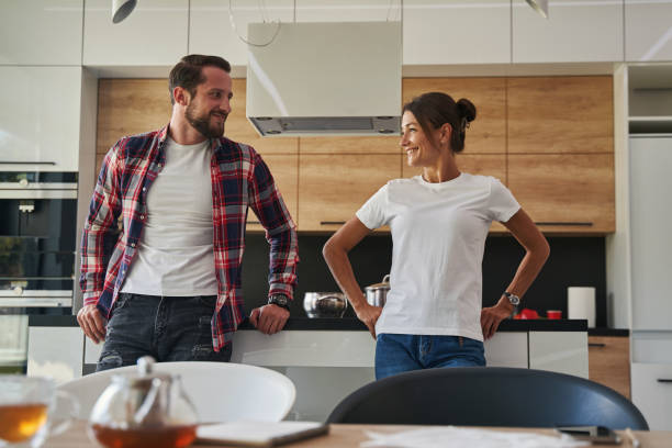 istock Charming lady talking with handsome male in the kitchen 1352115112