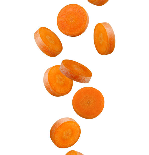отлично отретушированные круглые ломтики моркови летают в воздухе изолированно на белом фоне. - carotene healthy eating macro close up стоковые фото и изображения
