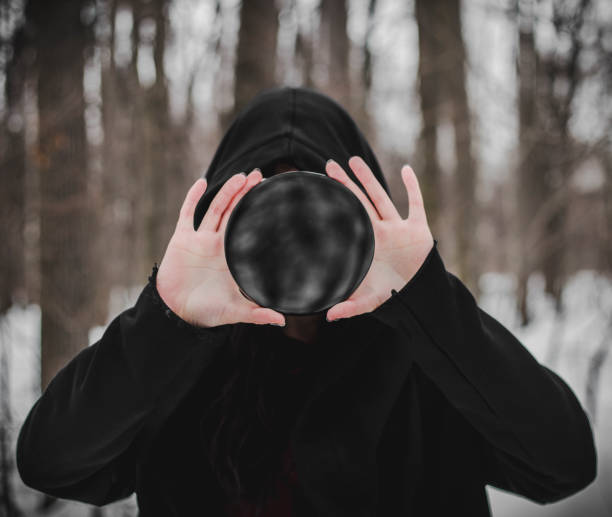 Fortune teller with Cristal ball on red velvet. Looking at crystal ball.