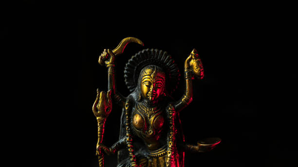 Kali goddess golden statue with red light wide format on black background Kali is a Hindu goddess, who is considered to be the Master of death, time and change. She is also said to be the Parvati, that is the supreme of all powers, or the ultimate reality. kali statue stock pictures, royalty-free photos & images