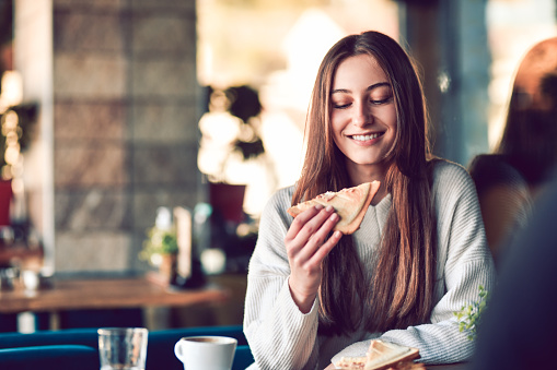 Adorable Female Smiling Before Taking Bite Of Toast Sandwich With Morning Coffee