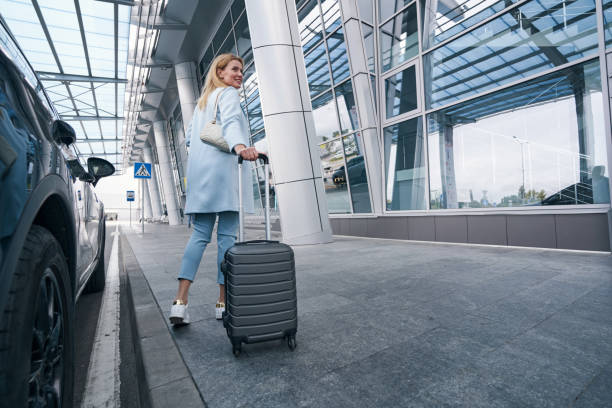 istock Pleased airline passenger with baggage looking away 1352121709