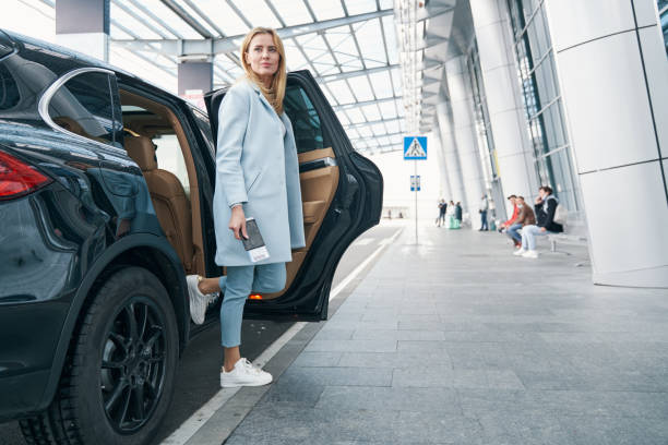 istock Woman with boarding ticket in her hand leaving car 1352121786