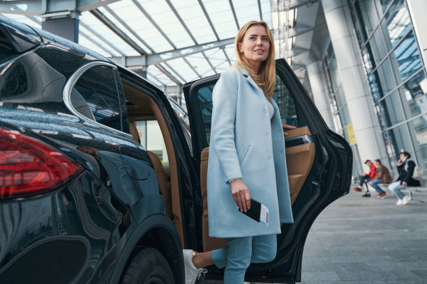 istock Pleased passenger with boarding ticket leaving taxi 1352121789