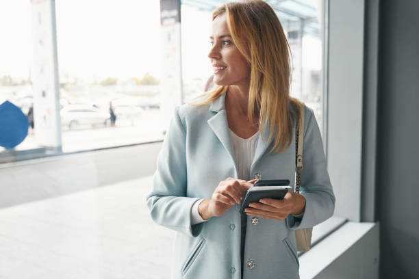 istock Joyous stylish female passenger looking into distance 1352121795