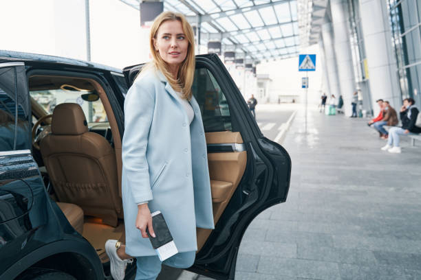 istock Lady with travel document getting out of cab 1352121805
